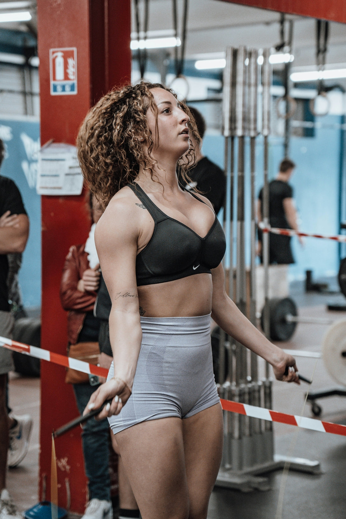 a woman in a black bra top and gray shorts