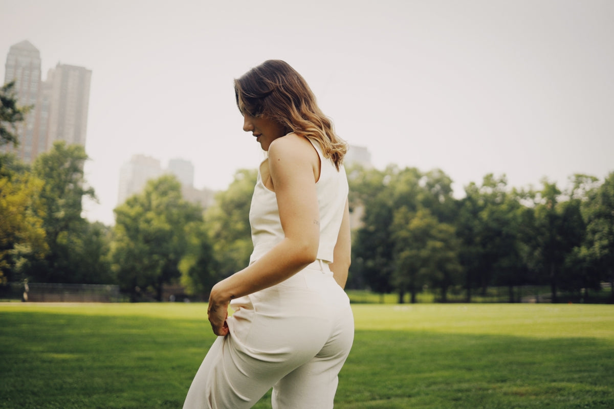 a woman in a white jumpsuit in a park
