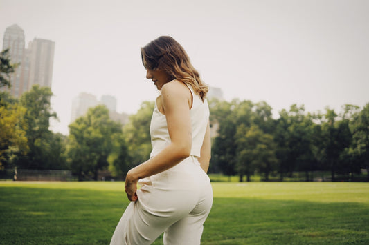 a woman in a white jumpsuit in a park