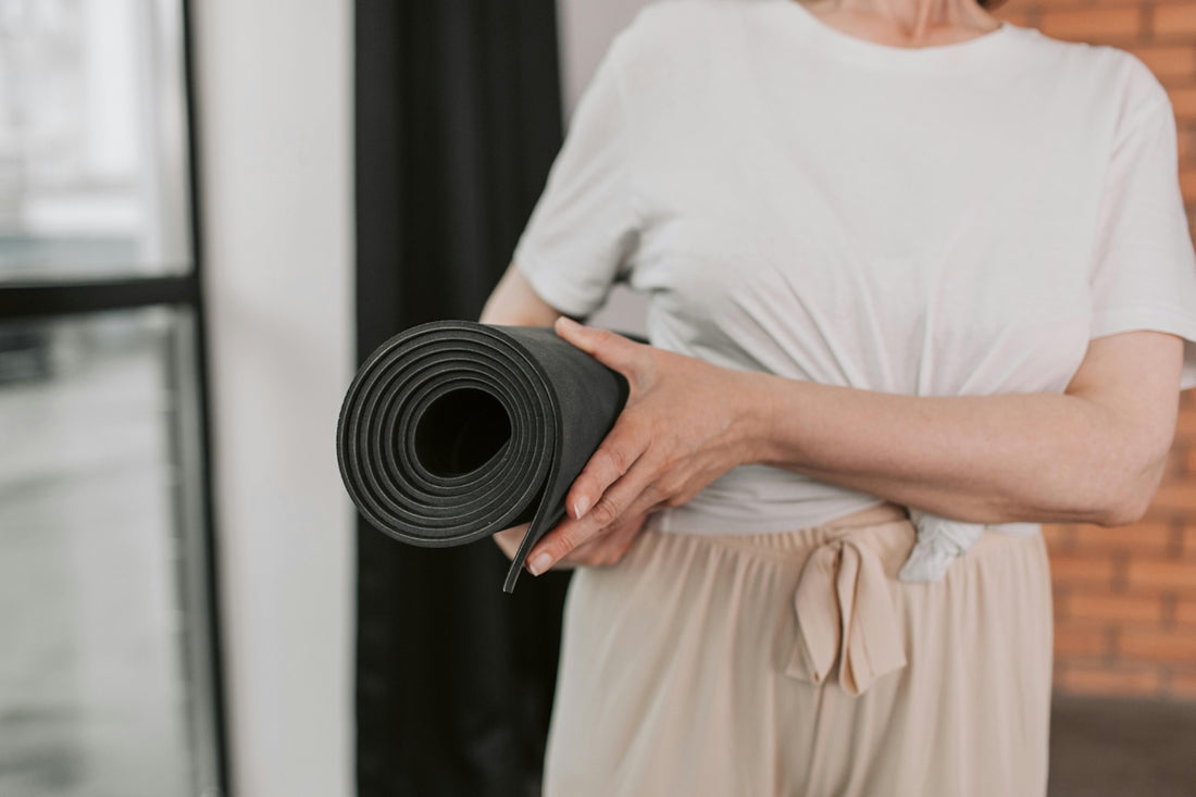 A woman holding a yoga mat in her hands