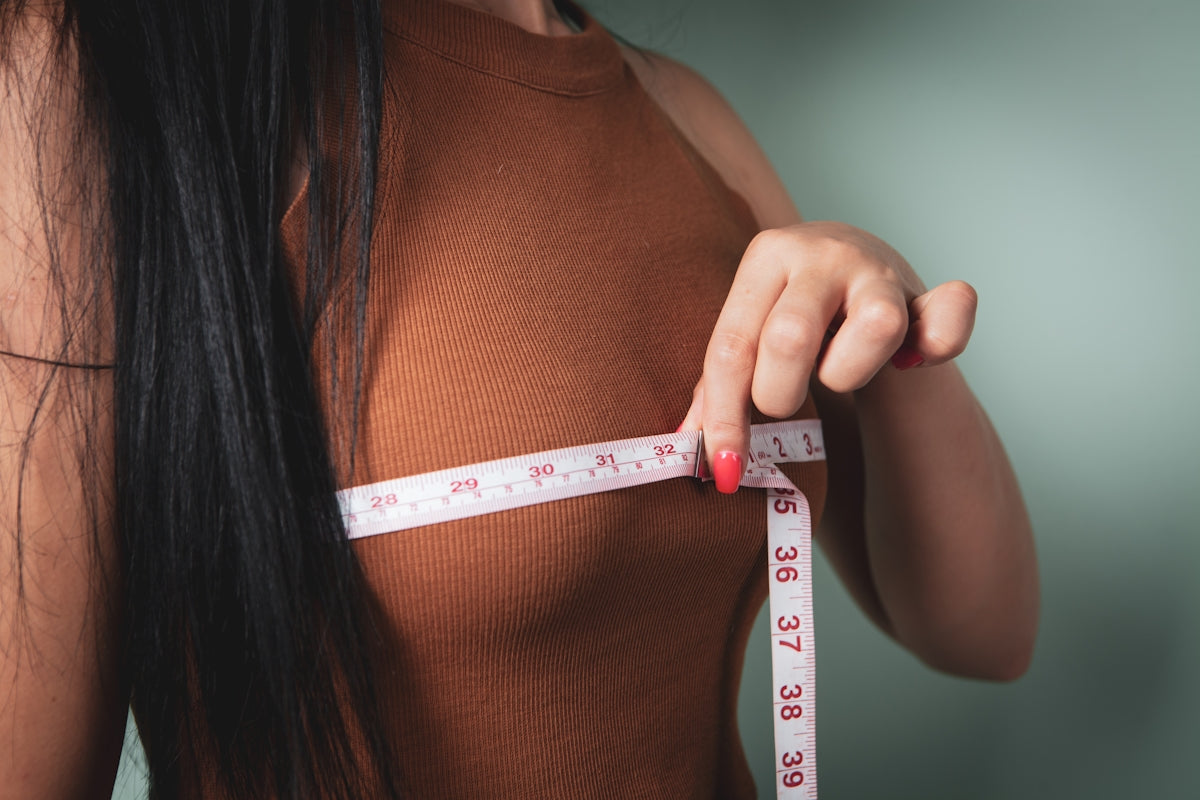 Woman measuring her bust with a tape measure.